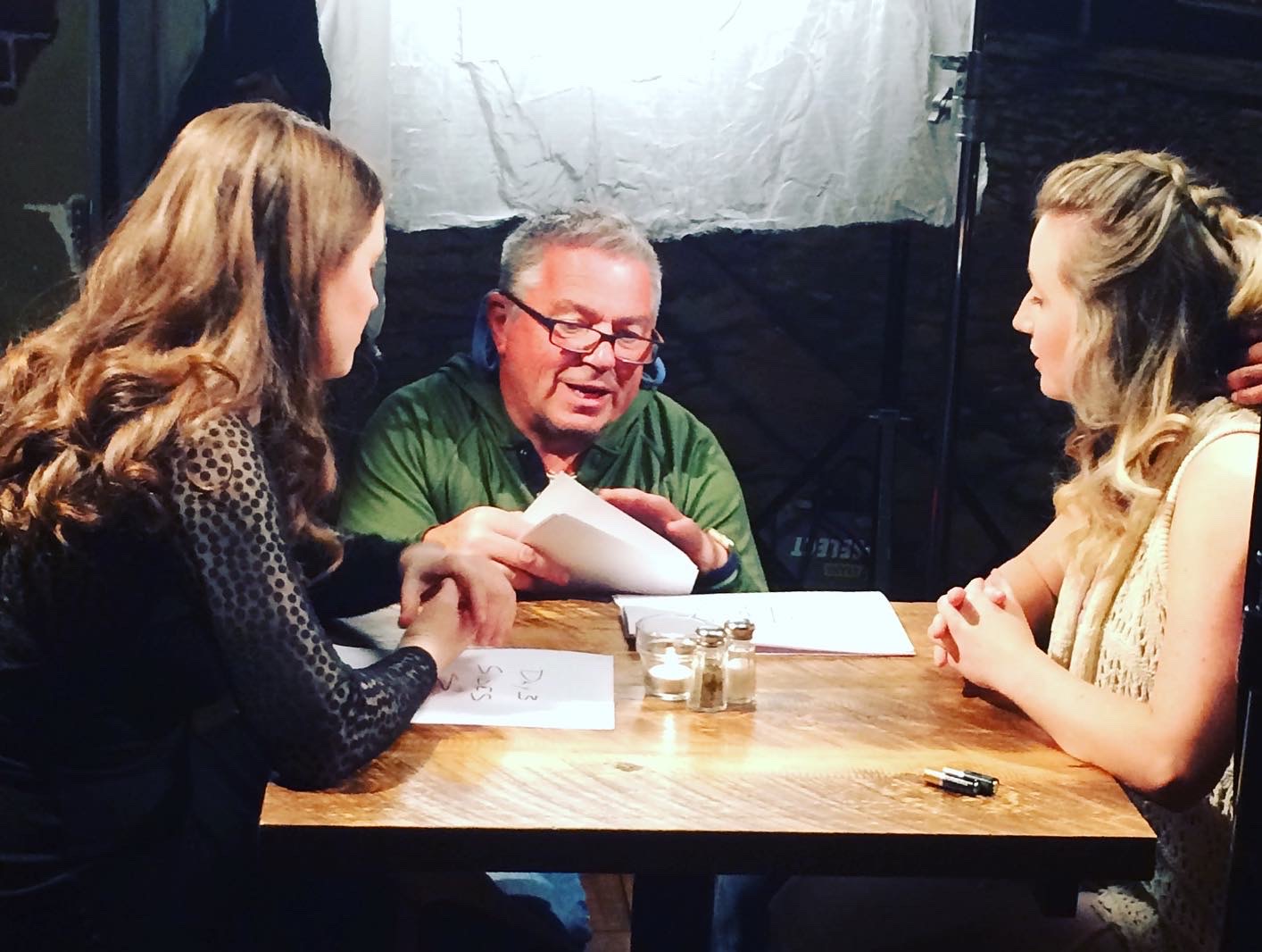 Ian Wilson discussing a script with two performers on set